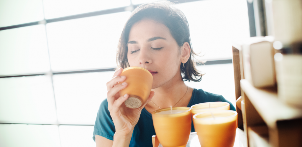 mulher cheirando uma vela